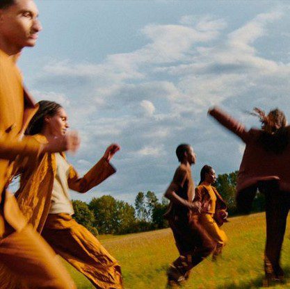 Group of people running outdoors in a field, symbolizing collaboration, diversity, and patient-centered progress in clinical research.