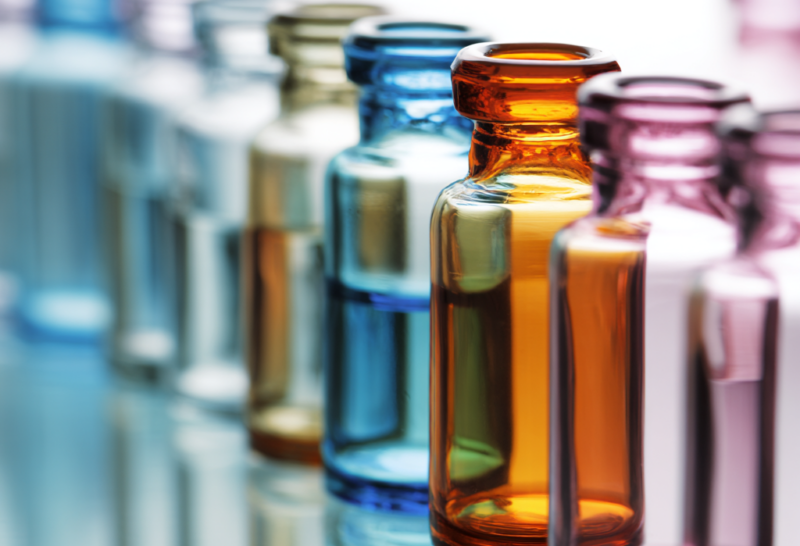 Row of colorful glass laboratory vials symbolizing early phase clinical research and safety evaluation