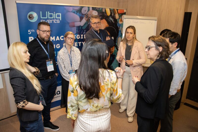 Participants discussing pharmacovigilance during a workshop at UBIQ events