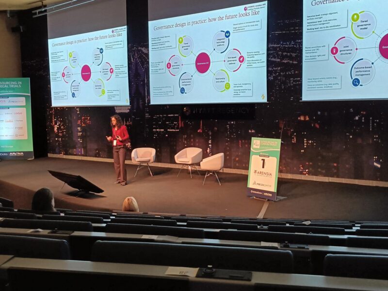 Speaker presenting a governance session at OCT Europe 2026 in Barcelona during a clinical trial outsourcing conference.